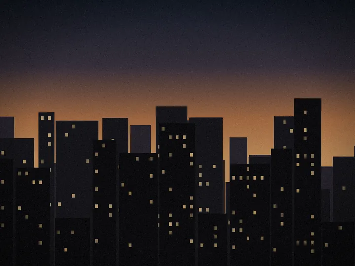 A city skyline at dusk with lit windows against an amber horizon.